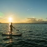 Muž na stand-up paddleboarde na mori.