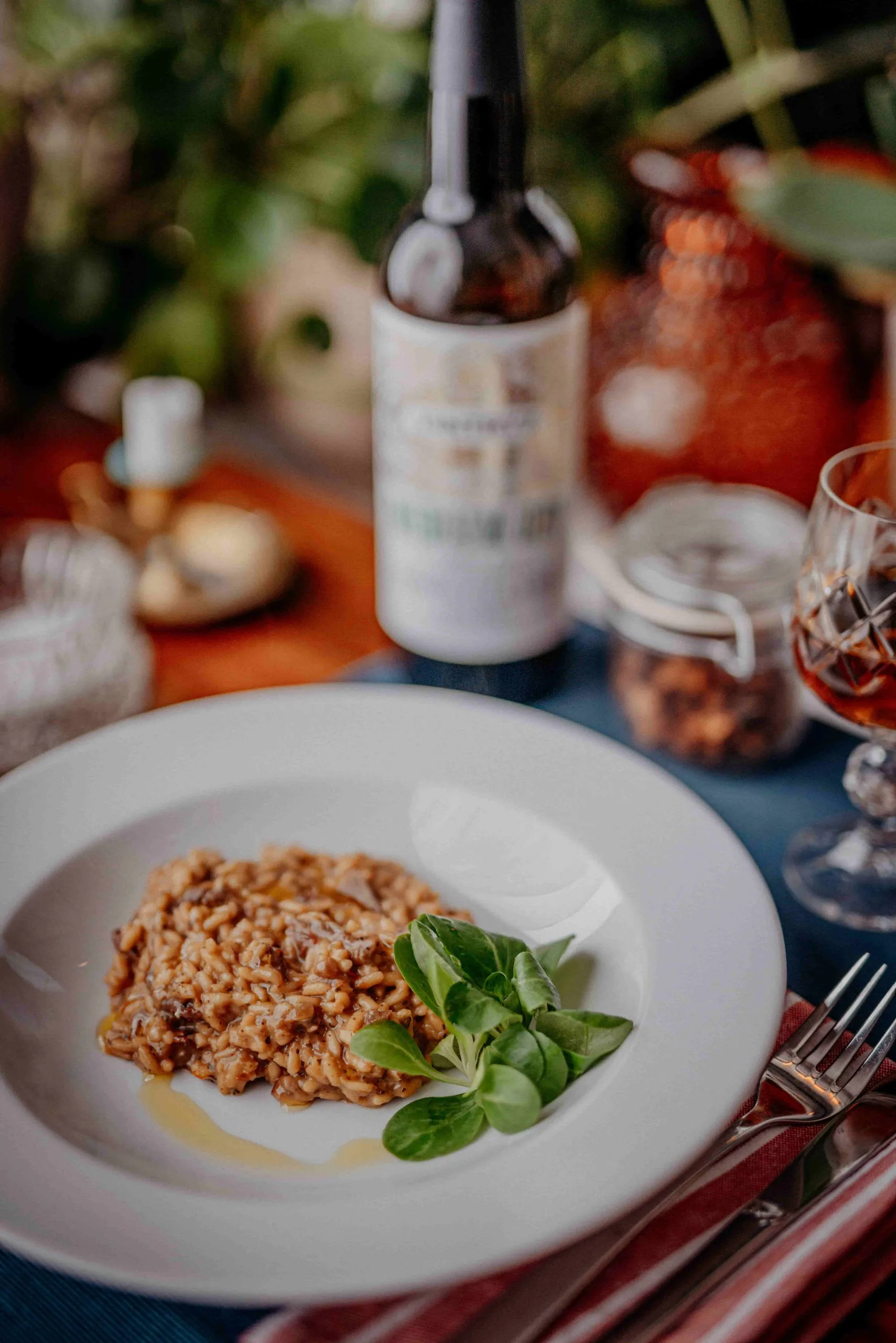 Beef risotto on a plate with wine bottle in the backgrownd