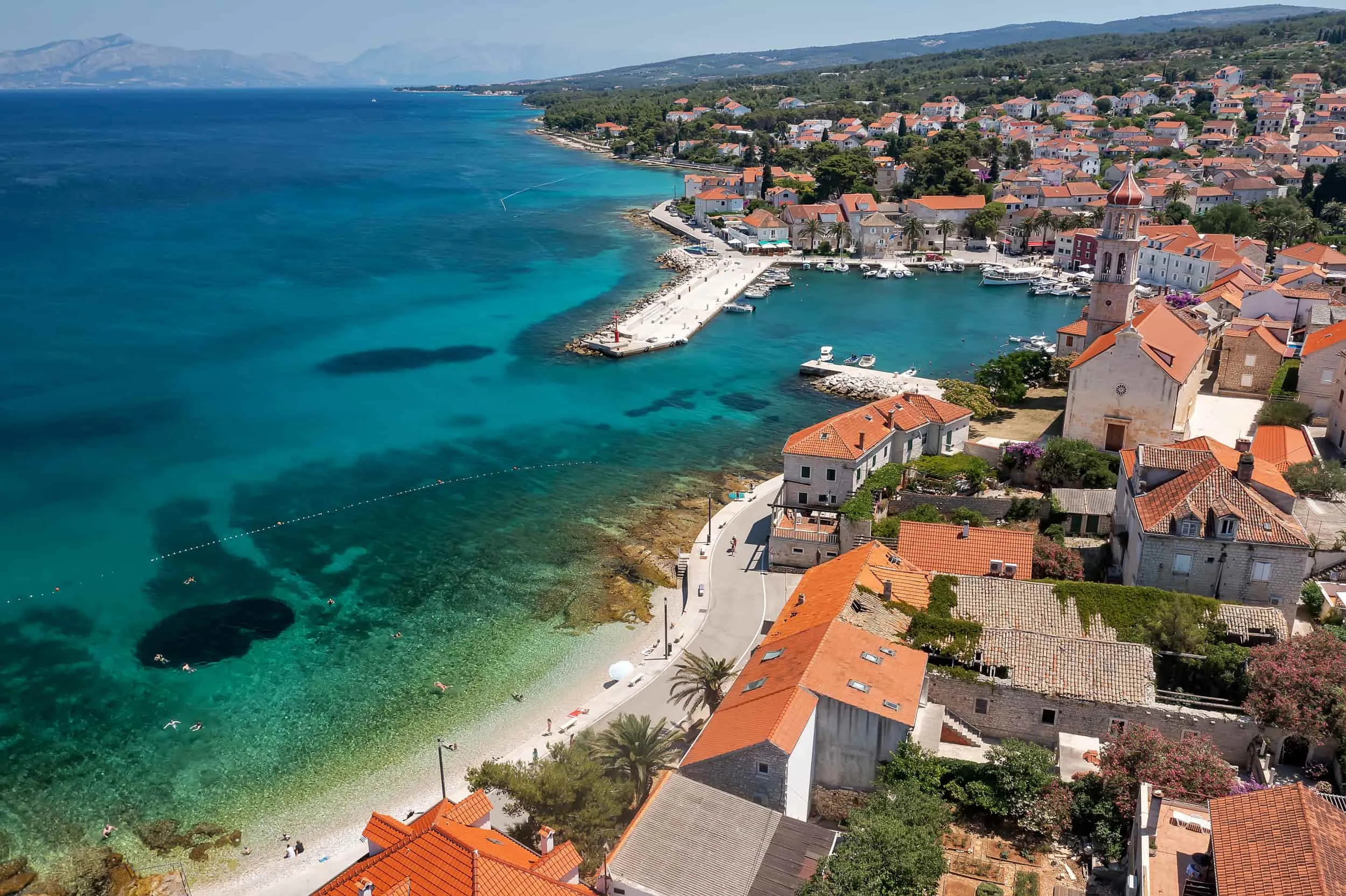 Légi felvétel Sutivanról, Brač szigetén, Horvátország. Egy festői tengerparti település kőházakkal, kis kikötővel és kristálytiszta tengerrel a kavicsos strand mellett.