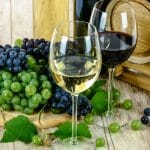 glasses of wine and grapes on a wooden table