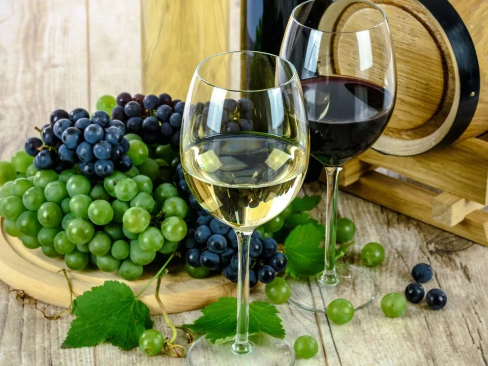 glasses of wine and grapes on a wooden table