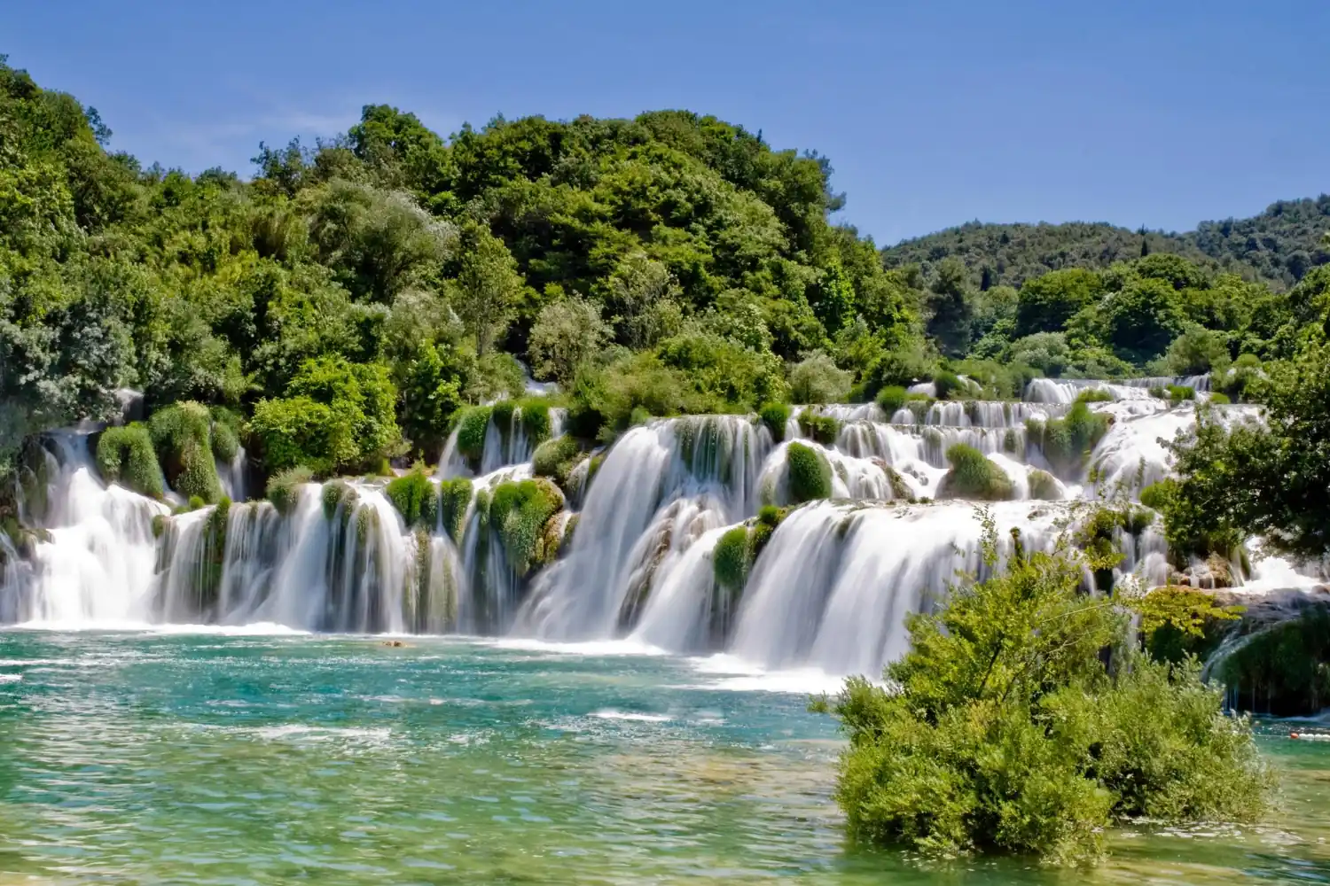 Skradinski Buk – the most famous waterfall in Krka National Park The magnificent Skradinski Buk waterfall in Krka National Park, surrounded by lush greenery.