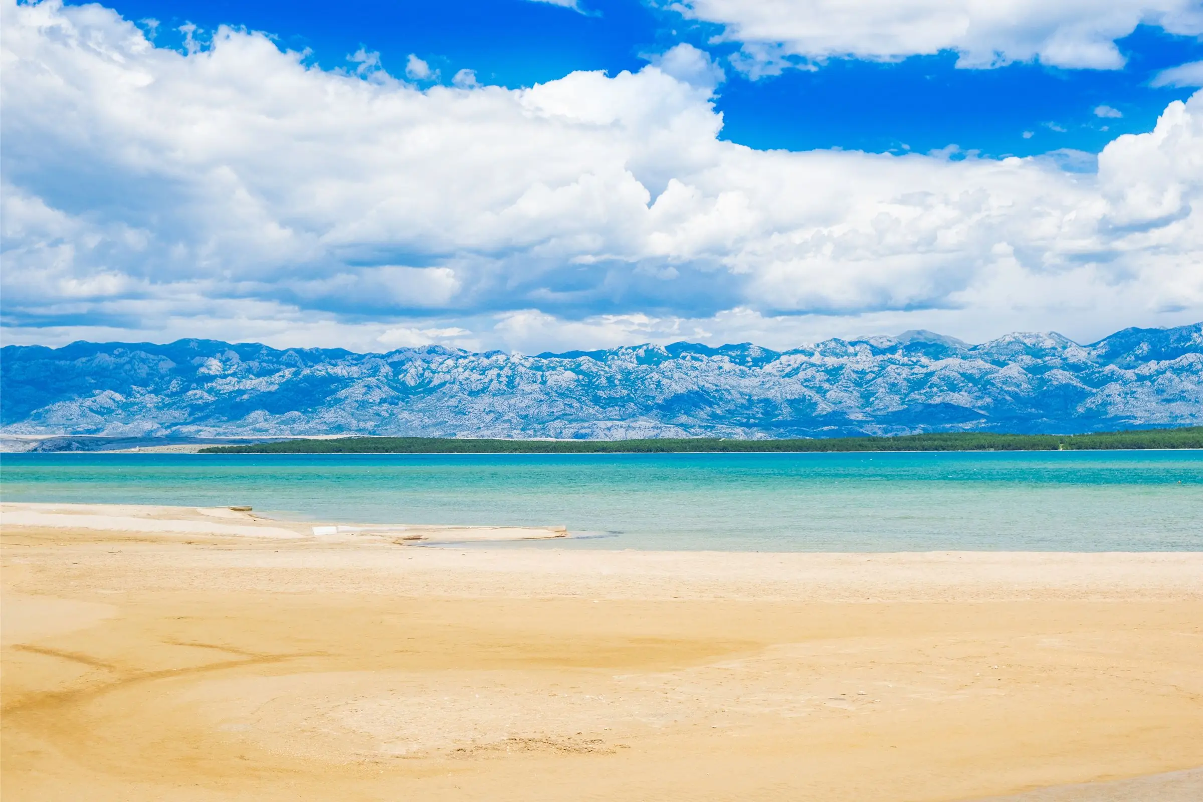 Der Strand der Lagune von Nin – eine sandige Lagune in der Nähe von Nin mit Blick auf den Velebit und seichtem Wasser