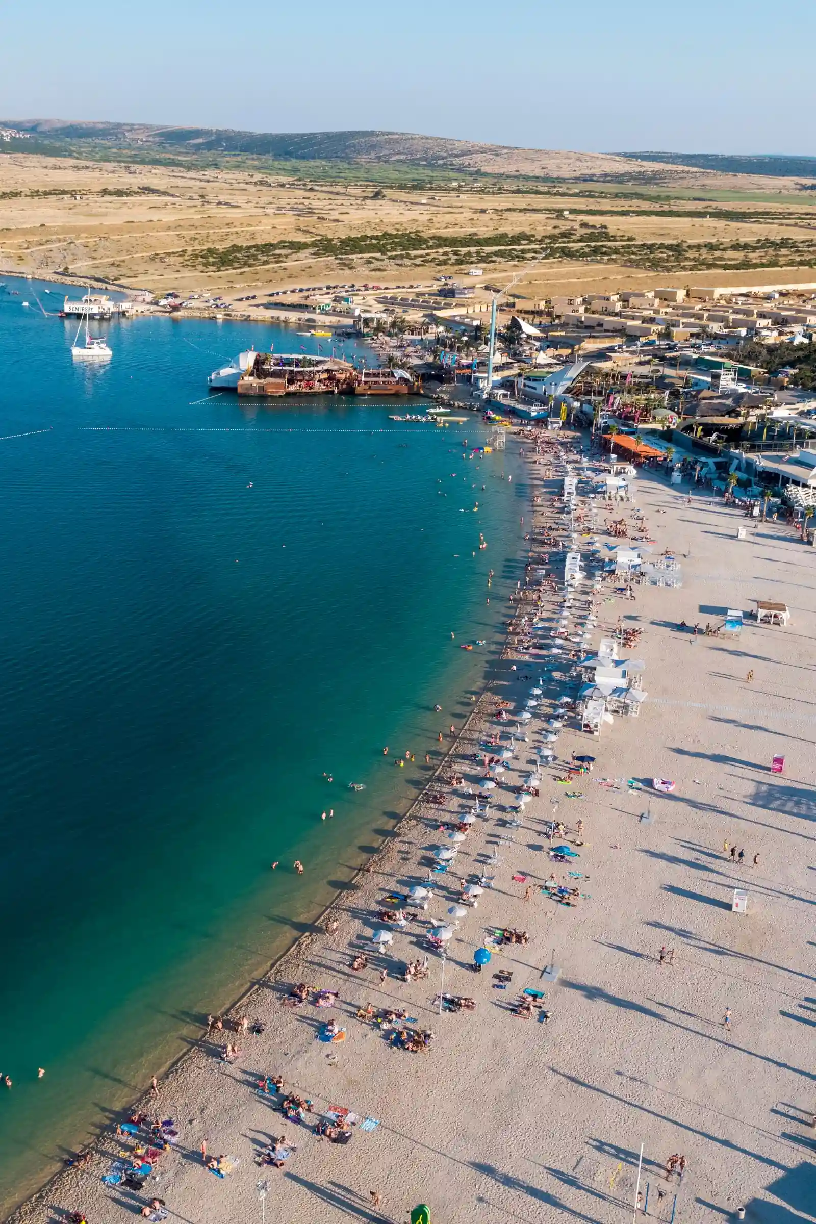 Zračna fotografija plaže Zrće — šljunčana uvala kraj Novalje s vidljivim beach klubovima