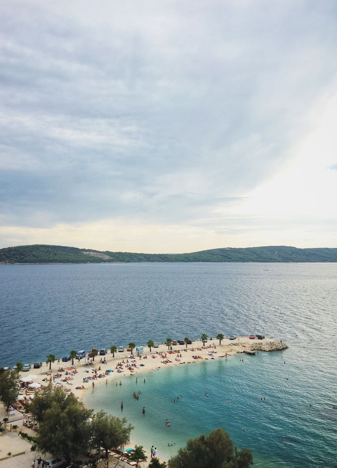 Zračni posnetek plaže Kašjuni — turkizen zaliv ob vznožju marjanskega borovega gozda